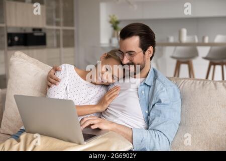 Close up loving young couple hugging, using laptop together Stock Photo