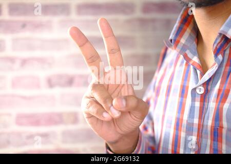 man hand showing victory gesture on white background  Stock Photo