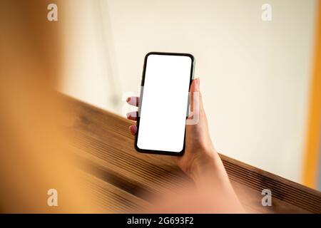 Woman using mobile phone with empty white screen, mockup for your app design. Stock Photo
