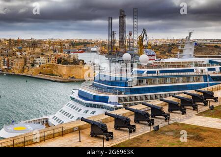 Valletta, Malta - October 10, 2019: Saluting Battery artillery cannons and cruise ship in the Grand Harbour Stock Photo