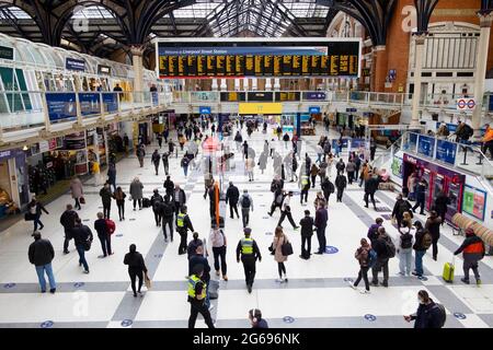 People passengers walking on the concourse and checking departure times at Liverpool Street Station during covid pandemic in London UK KATHY DEWITT Stock Photo