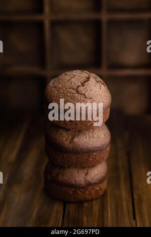 Chocolate homemade muffins stacked on a dark wooden table Stock Photo