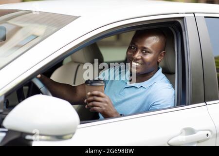 Smiling african american man driver drinking coffee Stock Photo