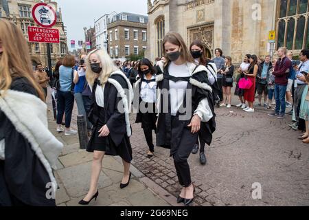 Picture dated July 3rd 2021 shows students from Murray Edwards College Cambridge on Saturday morning on their graduation day which has returned this week after the ceremony was cancelled last year due to the Coronavirus pandemic.  Students dressed in black gowns as the traditional Cambridge University graduation ceremonies took place – after they were cancelled last year due to the Coronavirus pandemic. The students paraded into historic Senate House to collect their degrees from the prestigious university. Family and friends would normally watch the ceremony inside the Senate House, but this Stock Photo