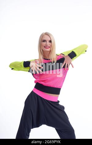 Time to move! Vertical studio shot of a beautiful happy young female dressed in sportswear dancing isolated on white Stock Photo