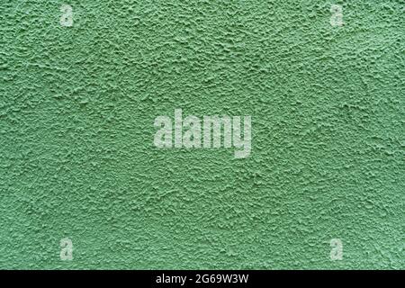 the plaster concrete wall is painted with green paint background Stock Photo