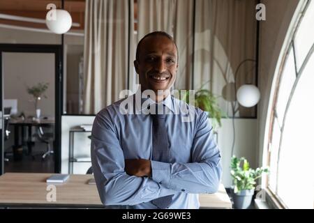 Head shot portrait smiling African American businessman with arms crossed Stock Photo