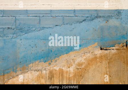 Brick wall with cement plaster and blue white paint, grunge background or texture Stock Photo