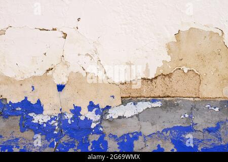 Old plastered with wall with blue indigo skirting board and peeling paint, traditional architecture in La Mancha, Spain Stock Photo