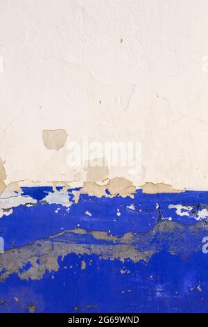 Old plastered with wall with blue indigo skirting board and peeling paint, traditional architecture in La Mancha, Spain Stock Photo
