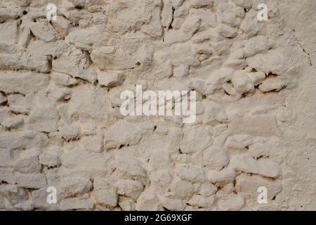 Old traditional limewashed stone wall, white rustic background or texture Stock Photo