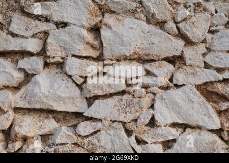 Old traditional limewashed stone wall, white rustic background or texture Stock Photo