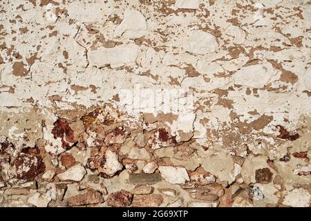 Old traditional limewashed stone wall with peeling plaster, white rustic background or texture Stock Photo