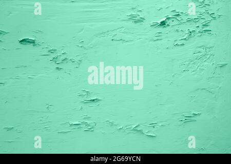 Pale green wall with peeling plaster Stock Photo
