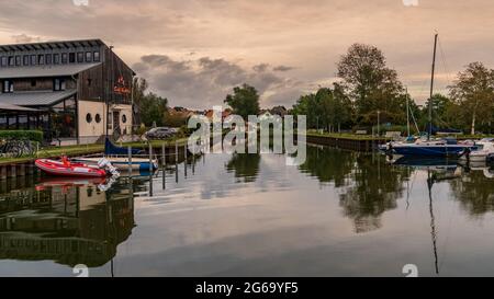 Ueckeritz, Mecklenburg-Western Pomerania, Germany - October 05, 2020: Boats in the Achterwasser harbour with a cafe on the left and the town in the ba Stock Photo