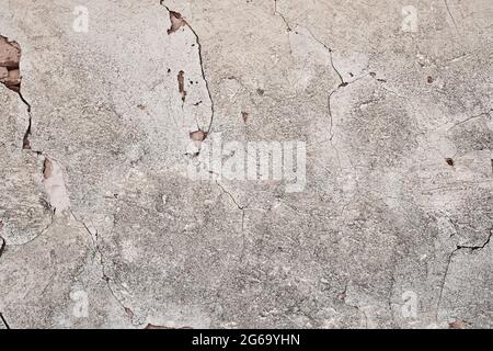 Old traditional limewashed stone wall with peeling plaster, white rustic background Stock Photo