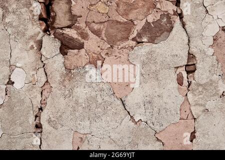 Old traditional limewashed stone wall with peeling plaster, white rustic background Stock Photo