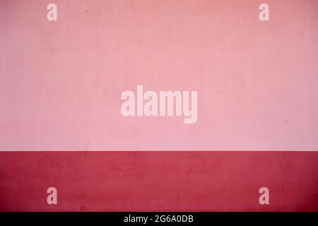 Pink concrete wall with red baseboard, abstract background or texture Stock Photo