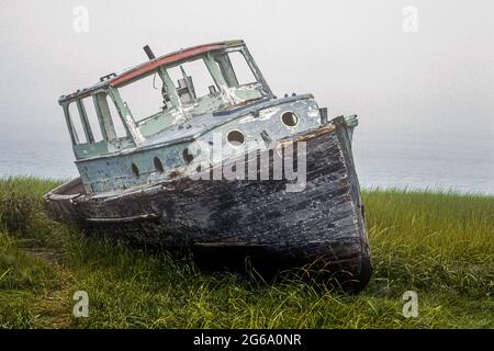 An old fishing boat left on the shoreline in Wellfleet, Massachusetts Stock Photo