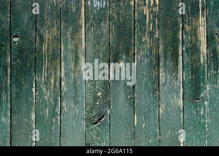 Old rustic wooden planks wall with dark green peeling paint, grunge background or texture Stock Photo