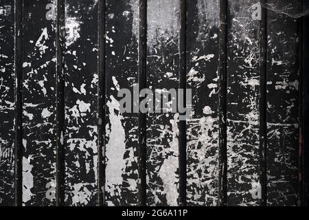 Old metallic shutter with worn out black peeling paint , grunge background or texture Stock Photo