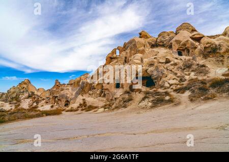 Uchisar, 04, October,2018:Volcanic rock formations with cave houses  against blue sky on Uchisar valley hills, Cappadocia, Turkey Stock Photo