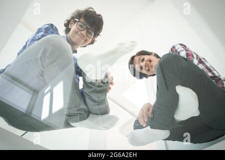 Low angle of father and sons sitting on glass Stock Photo