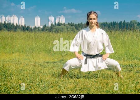 teen girl performing karate kata outdoors in kiba-dachi stance Stock Photo