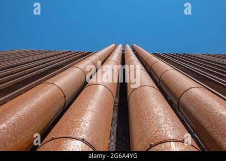 Modern urban background. Rusty papes on the building wall. Low angle view Stock Photo