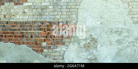 Beige plastered old brickwall with chipped stucco pieces. Grunge red brick wall with damaged surface background Stock Photo