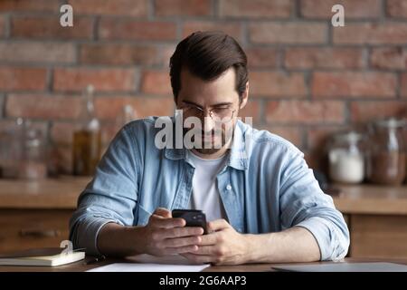Focused man using mobile service, online app on smartphone Stock Photo