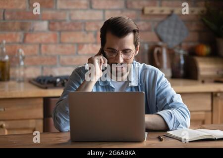 Serious millennial remote employee working at laptop from home Stock Photo
