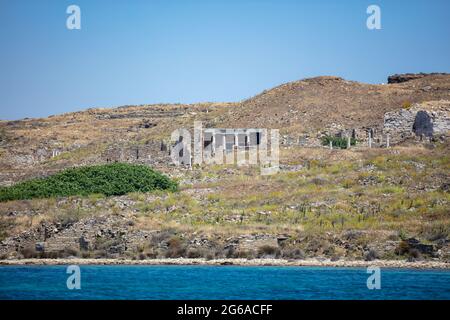 Delos the sacred Greece Cyclades island, House of tridents view from the sea. Ancient archaeological ruins, UNESCO Heritage site.  Stone walls and mar Stock Photo