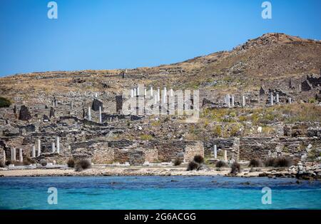 Delos Cyclades island, Greece. General view approaching by boat. Holy sanctuary archaeological site, UNESCO Heritage monument. Stone walls and marble Stock Photo