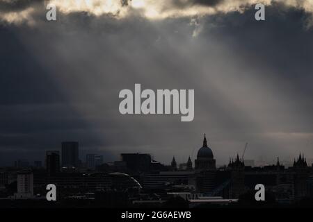 London, UK. 4th July, 2021. UK Weather: Dramatic evening sunset rays over the city illuminating St. Paul's Cathedral. Credit: Guy Corbishley/Alamy Live News Stock Photo
