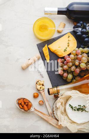 Mediterranean food drinks Ingredients set for dinner. Wine honey cheese nuts snacks bread grapes fruit on Light gray stone background. Gastronomy Stock Photo