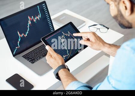 Close-up of tablet computer with graphs, diagrams and charts on screen in hands Stock Photo