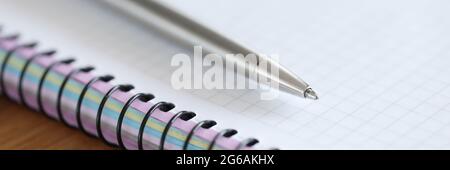Metal ballpoint pen lying on blank notebook closeup Stock Photo