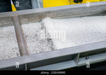 Recycled plastic granules on automatic conveyor belt, shale shaker Stock Photo