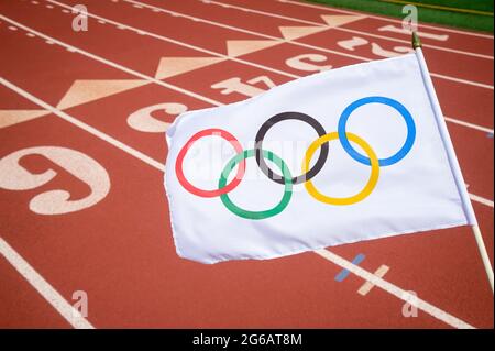 MIAMI, USA - AUGUST, 2019: An Olympic flag flutters above a red athletics track. Stock Photo