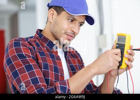 electrician testing socket with multimeter Stock Photo