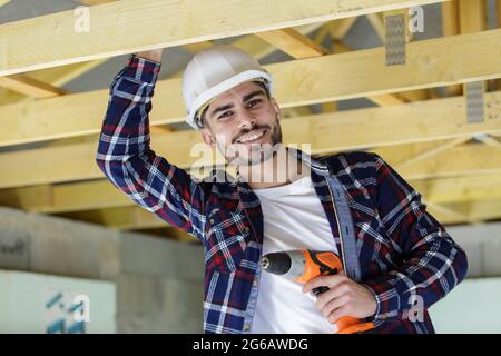 happy male construction worker adjusting ceiling Stock Photo
