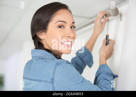 woman installing blinds with screwdriver Stock Photo