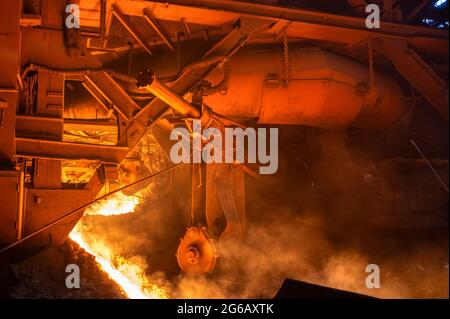 The process of tapping molten metal and slag from a blast furnace. Stock Photo