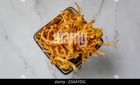 Crunchy deep fried Enoki Mushrooms with chilli flakes. Delicious snacks. Stock Photo