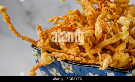 Crunchy deep fried Enoki Mushrooms with chilli flakes. Delicious snacks. Stock Photo