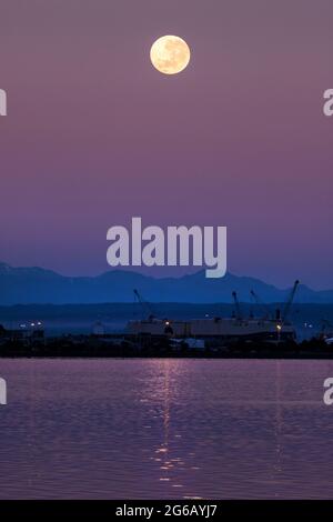 Picture by Tim Cuff 27 May 2021 - Blood Moon setting over Mount Owen and Port Nelson, Nelson, New Zealand Stock Photo