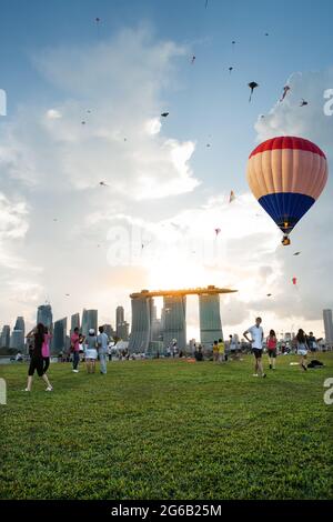 Marina Bay, Singapore - October 4, 2014: Aerial view of hot air balloon flying over Marina Barrage. scenic view of cityscape of Singapore with sunset Stock Photo