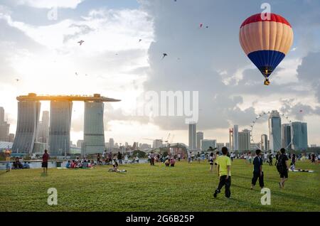 Marina Bay, Singapore - October 4, 2014: Aerial view of hot air balloon flying over Marina Barrage. scenic view of cityscape of Singapore with sunset Stock Photo