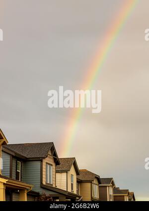 Rainbow over the row of new houses after a thunderstorm in Denver, Colorado Stock Photo
